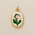 Détail d'un pendentif ovale doré avec motif de muguet sur fond en émail blanc poli - Pendentif Fleur de Mai