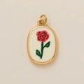 Gros plan du pendentif ovale doré avec motif de rose rouge sur fond blanc pur - Pendentif Fleur De Juin