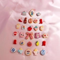 Colorful resin charm pendants with red high heels and cupcakes on pink satin background - Pizza Slice Pendant