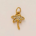 Dettaglio di un ciondolo a forma di palma in oro con cristalli pavé luccicanti - Palma