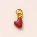 Detailed macro view of a glossy dark red heart charm with two gold-plated rings - January Heart Pendant