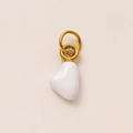 Close-up of a minimalist white heart pendant with polished golden metal ring connectors - April Heart Pendant