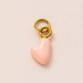 Close-up of heart pendant with pink enamel finish and gold-plated metallic double-loop ring - October Heart Pendant