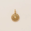 Macro-opname van gouden zonnestraal hanger met kristal op een crèmekleurige achtergrond - Zon Chakra Hanger / Goud