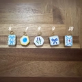 Detailed macro view of 18K gold-plated hand-painted bow and fruit pendant charms - No.6 Square Bowknot