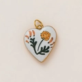 Macro shot of gold-plated stainless steel heart pendant with orange floral enamel patterns - Orange Floral Retro Heart Style