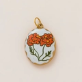 Detailed macro view of vintage oval gold pendant with hand-painted orange floral enamel inlay - Orange Floral Oval Style