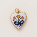 Macro detail of heart pendant with pink floral pattern and blue bow on 18K gold base - Pink Floral Blue Bow Heart Style