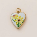 Detailed macro view of heart-shaped pendant with white enamel and yellow daisies in 18K gold - Yellow Daisy Heart Style