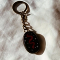 Macro detail of vintage oil painting heart snake keychain with bronze star and chain - Red Snake