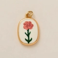 Detailed view of an oval 18k gold-plated pendant with pink embroidered flower pattern - January Flower Pendant / 1 Piece