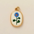 Macro shot of oval 18k gold-plated pendant with blue floral painted enamel and green leaves - September Flower Pendant / 1 Piece