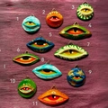 Macro view of eleven handmade colorful evil eye pendants with 18K gold plated wire hooks - Eye Pendant Style 1