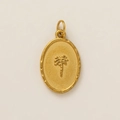 Detail of an oval gold-plated pendant featuring a palm tree relief and hammered edges - Coconut Tree Pendant