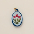Macro shot of oval ceramic pendant with hand-painted red tulips and blue border - Red Flower Pendant