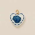 Detail eines weißen Keramik-Herzanhängers mit blauem Muschelmuster und goldenem Ring - Muschel-Anhänger