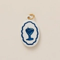 Detail of oval white enamel jewelry pendant featuring a blue cocktail glass design - Wine Glass Charm