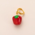 Detalle de pendiente de aro dorado con colgante de manzana en esmalte rojo brillante - Estilo Manzana Roja