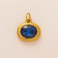 Macro detail of oval deep blue gemstone pendant with 18K gold-plated prong setting - Oval Birthstone Pendant / December