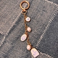 Détail d'un porte-clés doré avec breloques florales bleues et perles de nacre - Pendentif Coquille
