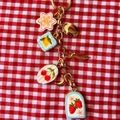 Porte-clés coloré avec pendentifs fleurs et fruits sur fond à carreaux rouge et blanc - Pendentif Fraise