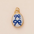 Ovale vergulde hanger met blauwe strikjesprints op een witte emaille achtergrond - Blauwe Strik Hanger Zonder Ketting