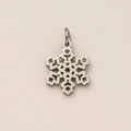 Détail macro du pendentif flocon de neige argenté avec design ajouré et poli - Pièce en flocon de neige / Acier