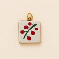 Detalle del colgante cuadrado dorado con diseño de bayas rojas y anillos dobles - Colgante Cereza Blanca