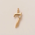 Macro shot of 18K gold-plated number seven pendant with a sparkling white zircon stone - Number 7 Style Pendant