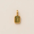 Detalle de un colgante de gema verde amarillenta corte esmeralda con marco de metal dorado - Colgante Cuadrado Marzo