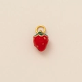 Detail eines roten Erdbeer-Anhängers mit grünen Blättern und goldener Öse für Schmuck - Erdbeere