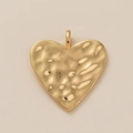 Detailansicht eines goldenen Herzanhängers mit Hammerschlag-Textur und poliertem Finish - Gold gehämmerter Herzanhänger