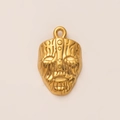 Makro-Detail des goldenen 18K vergoldeten Masken-Anhängers mit texturierter Oberfläche - Maske