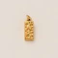 Détail d'un pendentif doré rectangulaire avec une texture unique en forme de cratère de fromage - Fromage