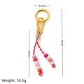 Handmade woven keychain in red and white with colorful beads and golden metal ring - Pink Cord Beaded Keychain