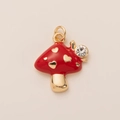 Detalle de un colgante de seta roja con corazones dorados y un caracol con pedrería - Colgante de Champiñón