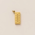 Gros plan détaillé d'un pendentif en forme de biscuit Bourbon plaqué or 18 carats avec texte - Biscuit Bourbon