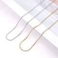 Detailed close-up of gold and silver stainless steel snake chains on a white display - Round Snake Chain / Silver