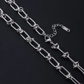Macro detail of silver stainless steel paperclip chain with knot design and lobster clasp - Knotted Bracelet Style / Steel