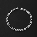 Macro view of a polished stainless steel Cuban link bracelet with a lobster clasp - Curb Chain / Width 5 Length 21