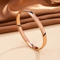 Detailed macro view of a rose gold 6mm curved stainless steel bangle with mirror finish - 6mm / Rose Gold (A616)