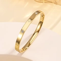 Detail of gold-plated stainless steel bangle featuring heart motifs and cubic zirconia - Gold