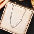 Detail view of a silver-toned thin link necklace with five oval beads on a luxury jewelry box - Steel Necklace (45+5cm)