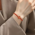 Close-up of golden four-leaf clover bracelet with red gemstones worn on the wrist - Four-leaf Flower Bracelet-Red