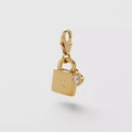 Gros plan d'un pendentif cadenas doré avec la lettre R et une petite pierre de zircon - Pendentif Cadenas Cœur