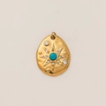 Vue détaillée d'un pendentif ovale en or avec pierre bleue et motifs de rayons stellaires - Étoile Brillante