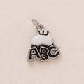 Dettaglio macro del ciondolo con lettere ABC in smalto bianco e nero e anello in metallo - Mela