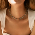 Collana boho con perline turchesi e tubi dorati indossata su top bianco con texture - Stile Consistenza Turchese (KN0289-2)