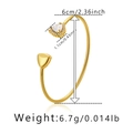 Detail view of a gold-plated cuff bracelet featuring a zircon inlay and heart charm - Clear Triangle Zirconia Style (KB0385-4)