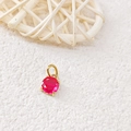 Macro view of 18k gold-plated birthstone pendant with red round-cut crystal in four-prong setting - July Rose - Gold